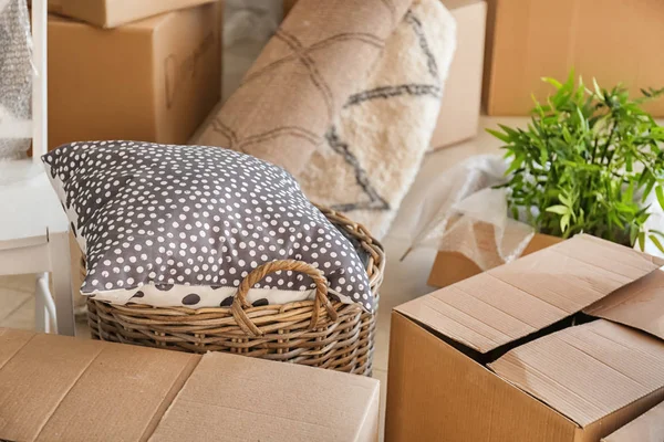 Carton boxes and interior items in room. Moving house concept