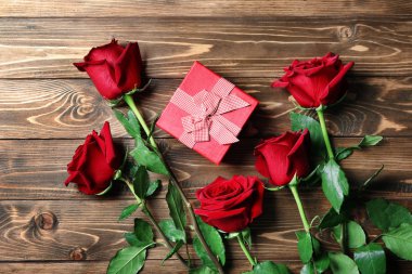 Hediye kutusu ve ahşap arka plan üzerinde güzel güller