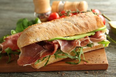 Ahşap masa, closeup prosciutto ile lezzetli sandviç