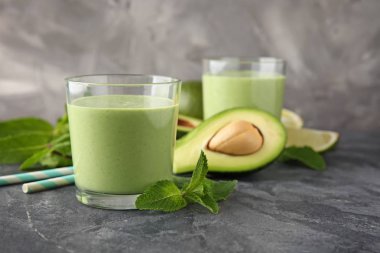 Gözlük lezzetli avokado güler yüzlü ve gri tablosundaki maddeler