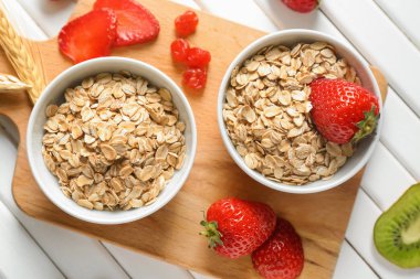 Yulaf ezmesi gevreği ve çilek beyaz tahta masada kompozisyonu