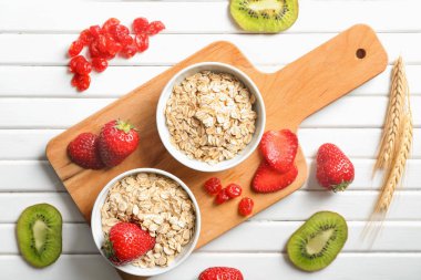 Yulaf ezmesi gevreği, çilek ve beyaz ahşap masa meyve kompozisyonu