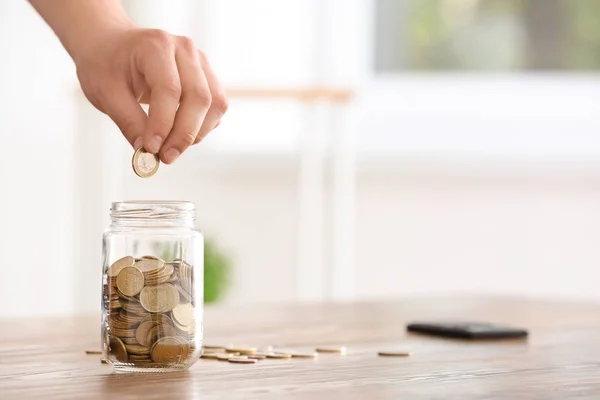 Man Lägga Mynt Glasburken Bordet Besparingar Koncept — Stockfoto