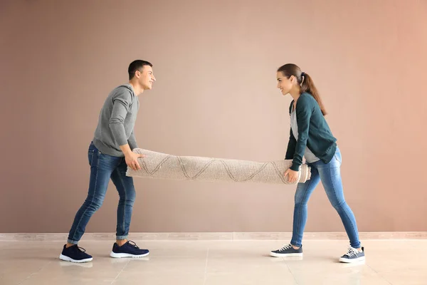 Casal Jovem Transportando Tapete Dentro Casa Mudando Para Casa Nova — Fotografia de Stock