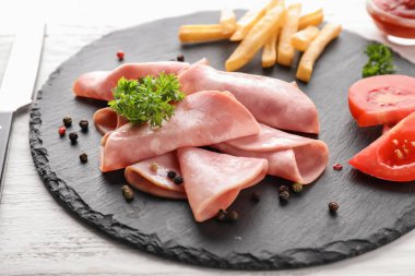 Ahşap masa lezzetli dilimlenmiş jambon ile kayrak plaka