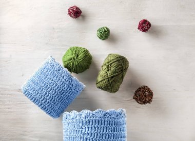 Beyaz ahşap masa üzerinde iplik örgü ile sepetleri