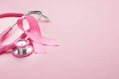 Renkli arka planda pembe kurdele ve steteskop. Göğüs kanseri farkındalığı konsepti