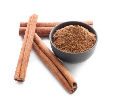 Aromatik tarçın çubukları ve beyaz arkaplanda pudra