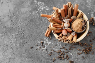 Tarçın, fındık ve gri arka plan üzerine şeker ile kase