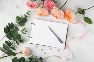 Güzel çiçekler ve açık renkli defter kompozisyonu