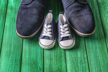 Ahşap arka plan üzerinde büyük ve küçük ayakkabılar. Babalar günü kutlama