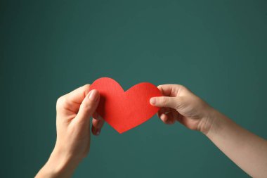 Anne ve çocuk renk arka plan üzerinde kağıt kırmızı kalpli