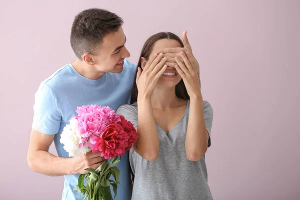 Joven Sosteniendo Hermosas Flores Cubriendo Los Ojos Amada Novia Fondo — Foto de Stock