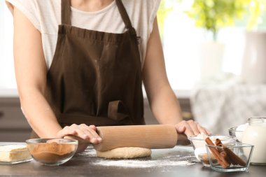 Hamur tarçınlı çörek için masada haddeleme kadın