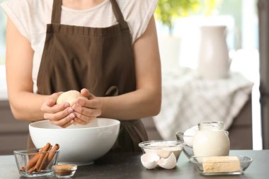 Kadın mutfakta tarçınlı çörek için hamur yoğurma
