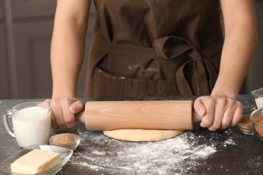 Hamur tarçınlı çörek için masada haddeleme kadın