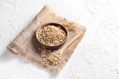 Kase ve kaşık ışık arka plan üzerinde çiğ yulaf ezmesi ile