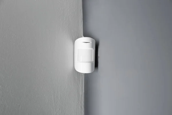 Modern motion sensor on wall indoors