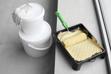 Merdane ve pencere kapalı yakınındaki kova ile boya tepsi