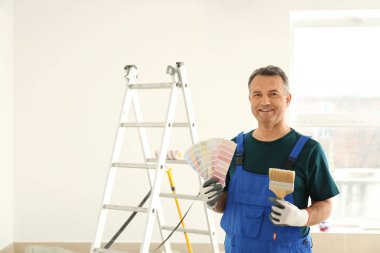 Renk paleti örnekleri ve kapalı fırça ile üniformalı erkek ressam