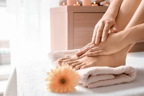 Young woman with beautiful pedicure and manicure after treatment in spa salon