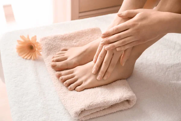 Young woman with beautiful pedicure and manicure after treatment in spa salon