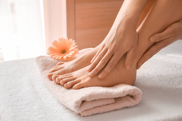 Young woman with beautiful pedicure and manicure after treatment in spa salon