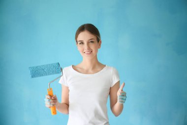 Genç kadın ressam rulo renk arka plan üzerinde