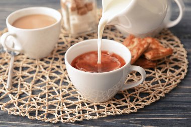 Süt çay fincan ahşap masanın üstüne dökme.