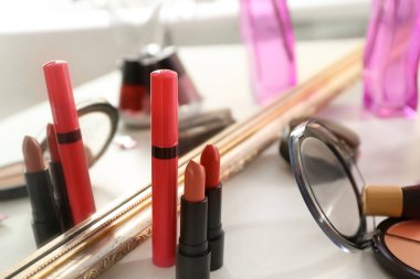 Dekoratif kozmetik ayna yakınındaki masada kümesi