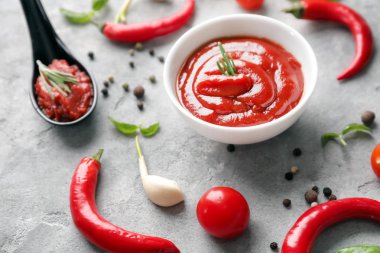 Lezzetli domates sosu ve biber gri masada kompozisyonu