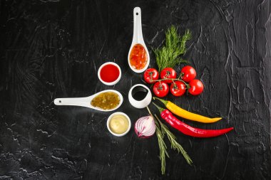 Siyah dokulu arka plan, üstten görünüm üzerinde farklı sos ile kompozisyon