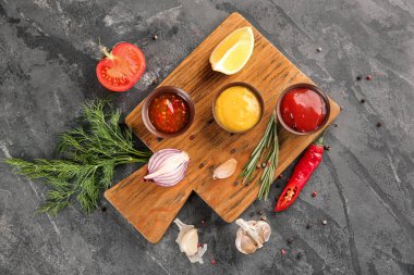 Gri dokulu arka plan üzerinde lezzetli soslar ile kompozisyon