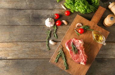 Çiğ et ve ürünleri ahşap arka plan üzerinde düz yatıyordu kompozisyonu