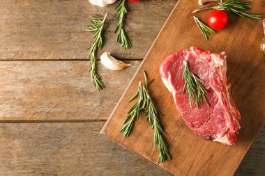 Çiğ et ve ürünleri ahşap arka plan üzerinde düz yatıyordu kompozisyonu