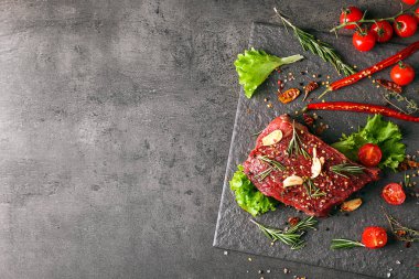 Çiğ et ve sebze gri arka plan, üstten görünüm üzerinde arduvaz levha
