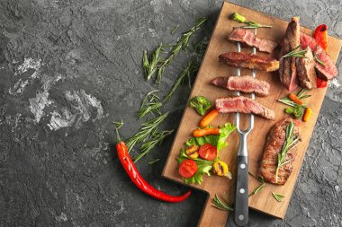 Et ve sebze garnitür gri arka planda, üstten görünüm ile ahşap tahta