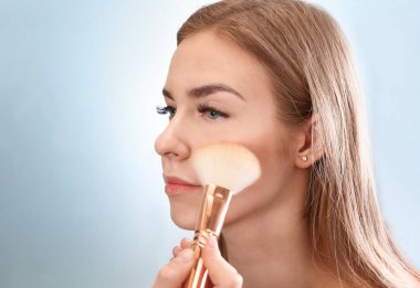 Güzellik Salonu genç kadının yüzünde makyaj uygulamak profesyonel makyaj sanatçısı