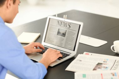 Genç işadamı dizüstü bilgisayar ekranında Office haber okuma