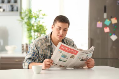 Kahvaltı sırasında evde sabah gazete okuyan adam