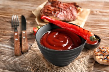 Ahşap masa üzerinde Barbekü sosu ile kase