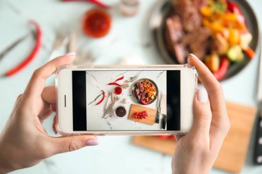 Kadın alarak fotoğraf ile hareket eden telefon, üstten görünüm ızgara et ve barbekü sosu