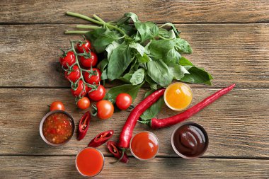 Farklı sos ve malzemeler ahşap arka plan üzerinde düz yatıyordu kompozisyonu