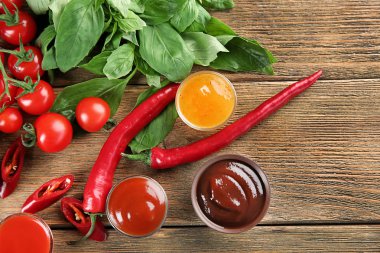 Farklı sos ve malzemeler ahşap arka plan üzerinde düz yatıyordu kompozisyonu