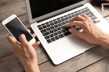 Cep telefonu ve dizüstü evde, closeup ile genç serbest meslek