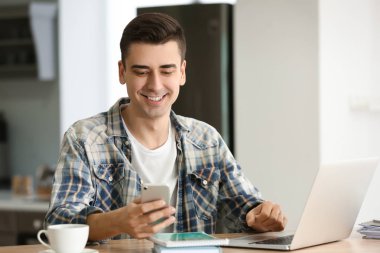 Cep telefonu ve dizüstü evde genç serbest meslek