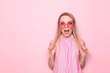 Renkli arka planda şaşırmış genç bir kadın.