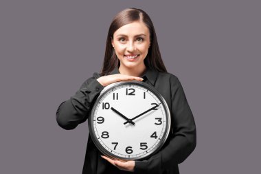 Gri arka plan üzerinde saat olan kadın. Zaman yönetimi kavramı