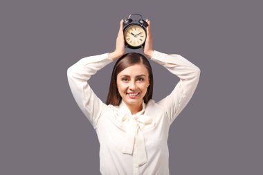 Çalar saat gri arka plan üzerinde olan kadın. Zaman yönetimi kavramı