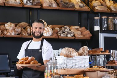 Erkek baker dükkanda holding lezzetli kruvasan ile ahşap Yönetim Kurulu